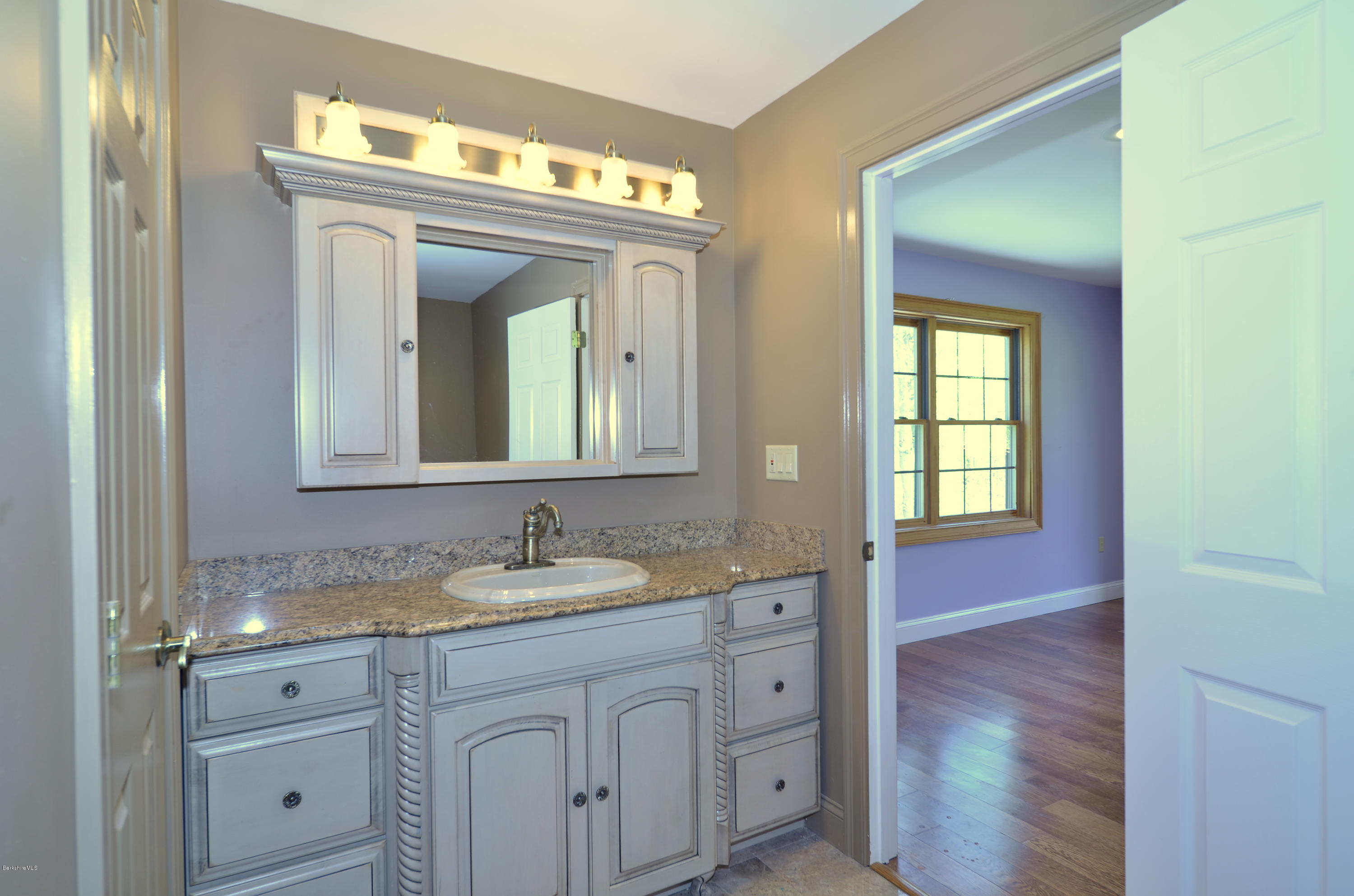 317 Skyline Ridge Road Becket, MA 01223 - Photo 22 of 29 a bathroom with a granite countertop sink vanity and mirror