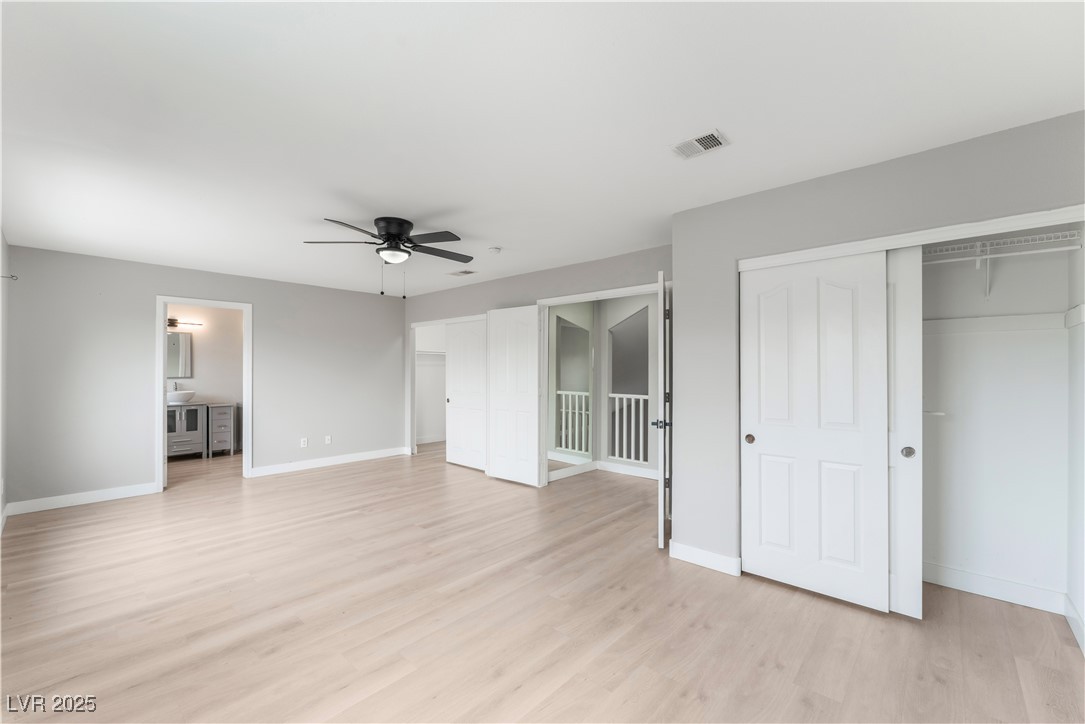 3695 Funston Way Las Vegas, NV 89129 - Photo 29 of 43 Unfurnished bedroom featuring light wood-style floors, a ceiling fan, and multiple closets