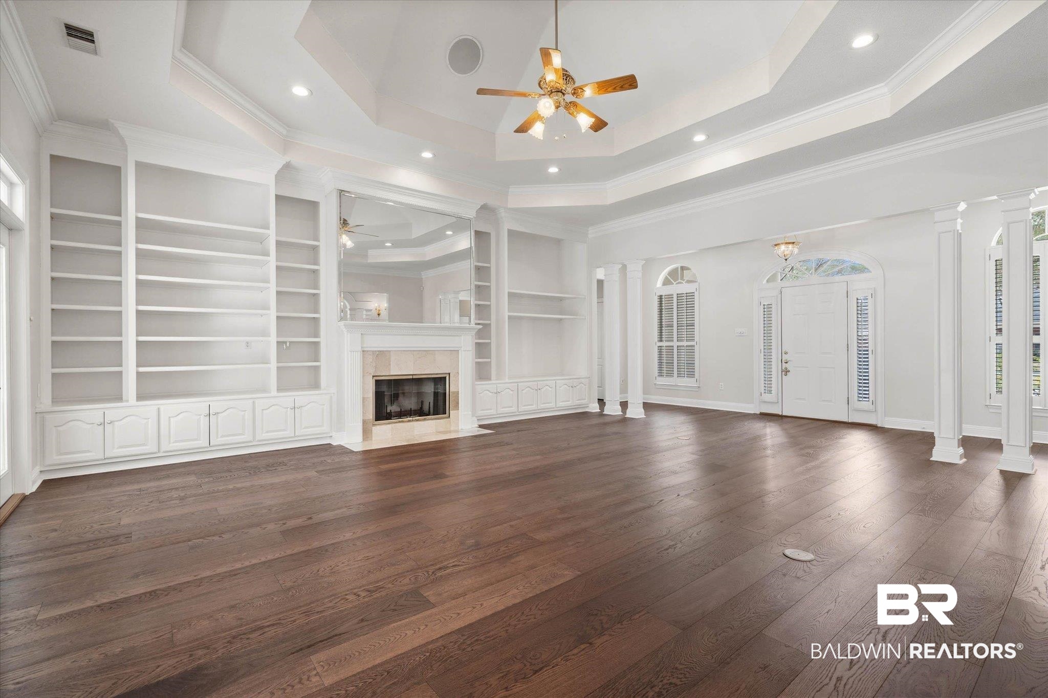 1083 Southern Way Court Mobile, AL 36609 - Photo 5 of 31 Unfurnished living room with dark wood-style flooring, crown molding, a ceiling fan, a high end fireplace, and built in features