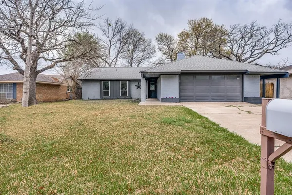 a front view of a house with a garden and trees