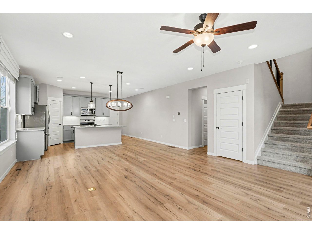2124 Glean Court Windsor, CO 80550 - Photo 12 of 40 a view of kitchen with refrigerator microwave and wooden floor