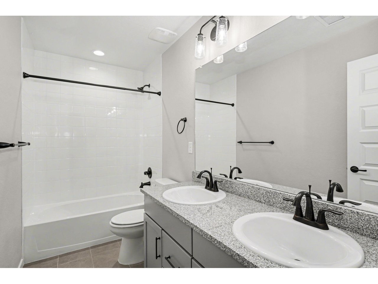 2124 Glean Court Windsor, CO 80550 - Photo 19 of 40 a bathroom with a granite countertop sink a toilet a mirror and shower