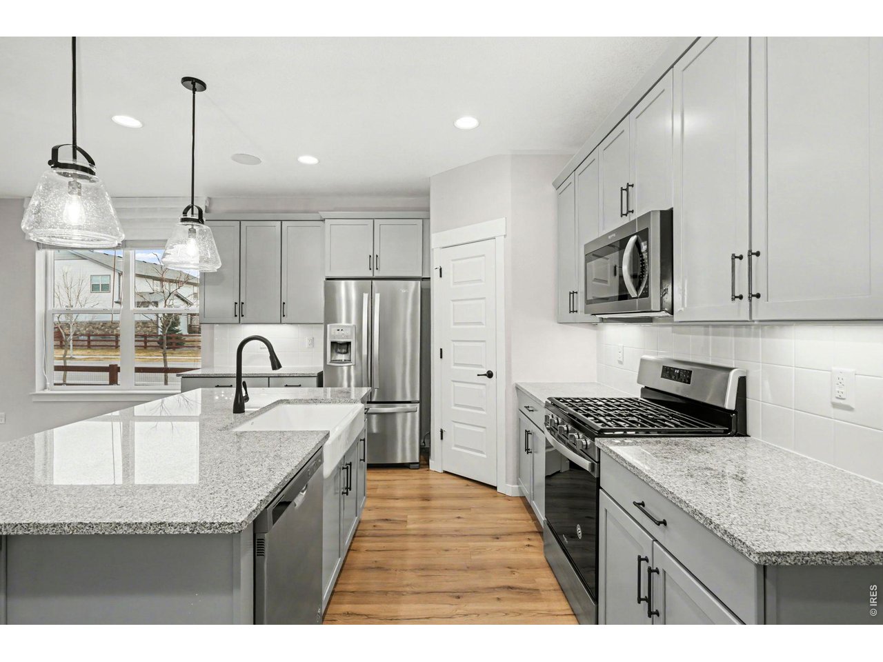 2124 Glean Court Windsor, CO 80550 - Photo 5 of 40 a kitchen with stainless steel appliances granite countertop a sink stove and refrigerator