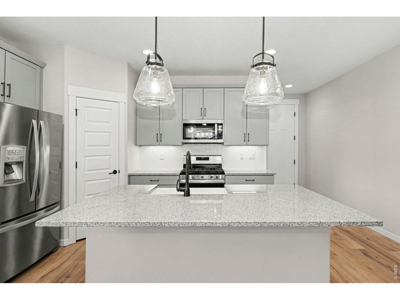 2124 Glean Court Windsor, CO 80550 - Photo 7 of 40 a kitchen with stainless steel appliances granite countertop a sink a refrigerator and a stove
