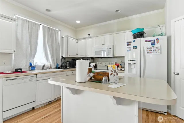 a view of kitchen with sink refrigerator and window