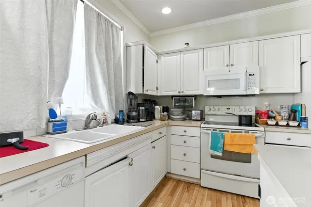a kitchen with white cabinets and white appliances