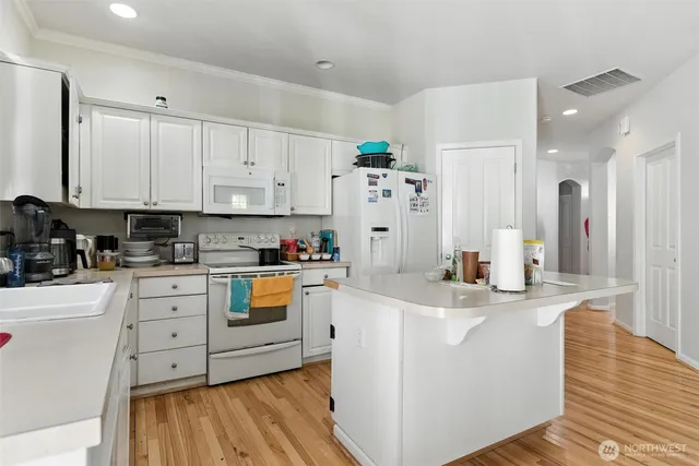a kitchen with stainless steel appliances a refrigerator sink and white cabinets