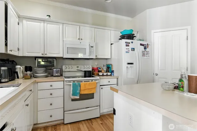 a kitchen with stainless steel appliances white cabinets and a refrigerator