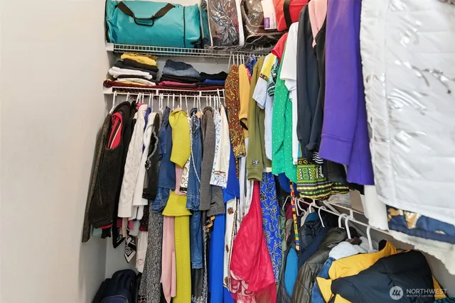 a view of walk in closet with clothes and shoes