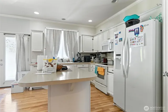 a kitchen with stainless steel appliances a refrigerator sink and white cabinets