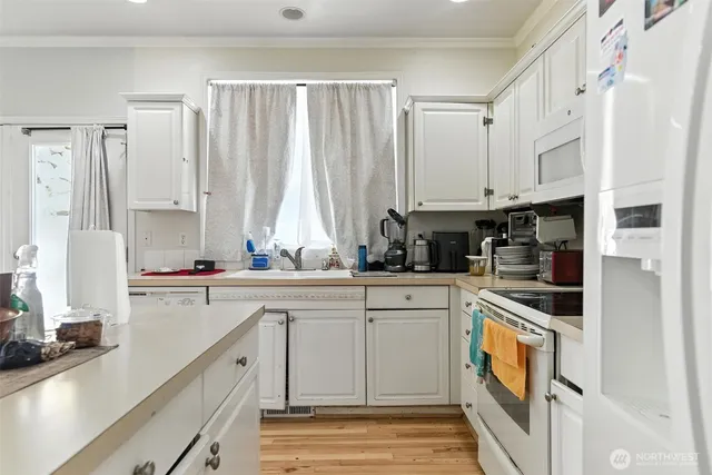 a kitchen with stainless steel appliances white cabinets and a sink