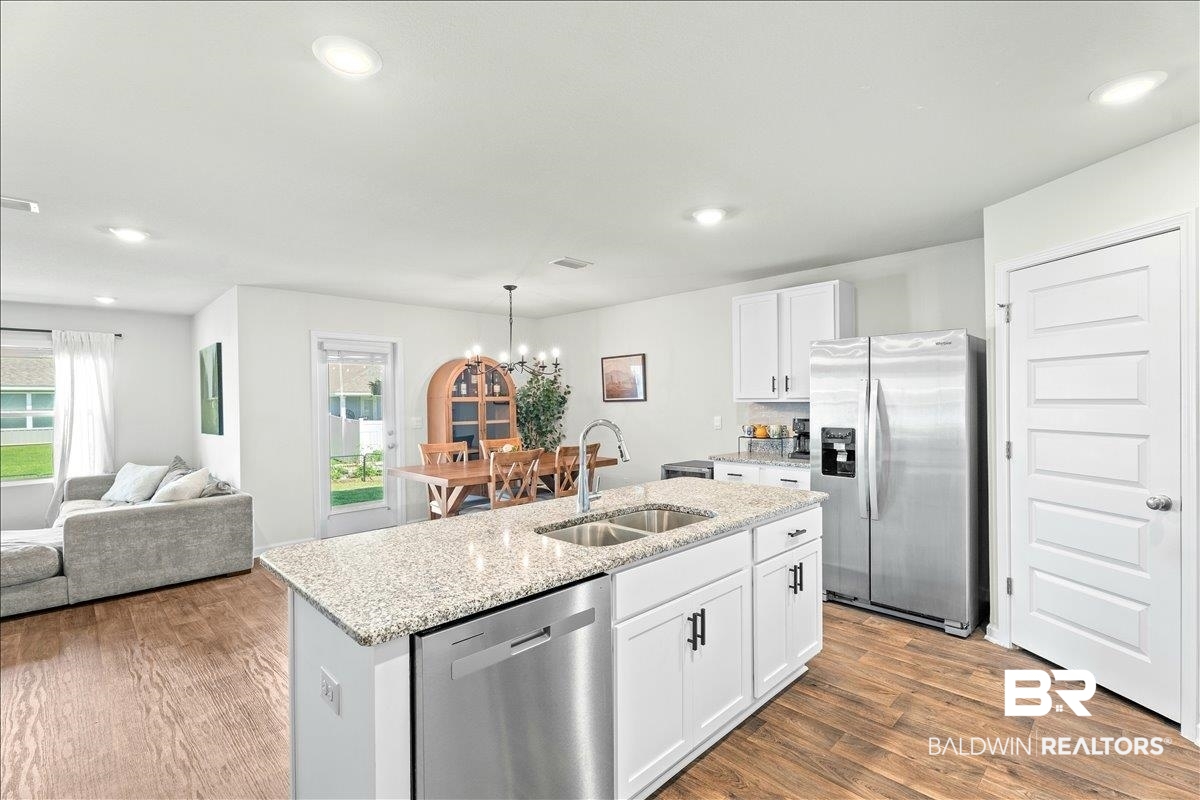 23641 Unbridled Loop Daphne, AL 36526 - Photo 7 of 40 Kitchen island featuring a double-basin stainless steel sink and granite countertop