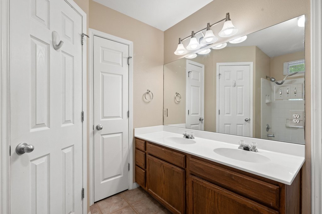 5208 Sioux Lane Austin, TX 78734 - Photo 23 of 35 Dual vanity with integrated sinks offers ample space for morning routines, framed by a wide mirror and bright lighting.