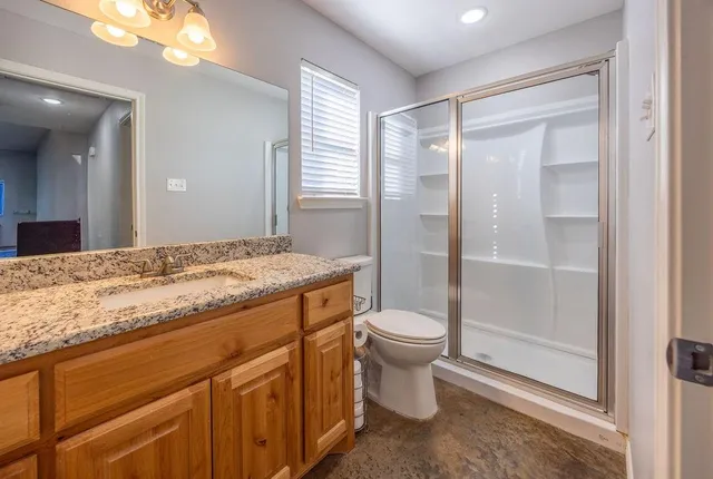 a spacious bathroom with a granite countertop sink toilet and shower