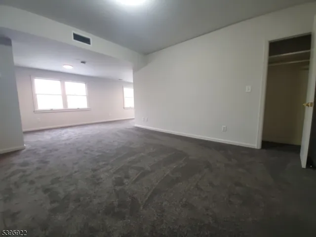 an empty room with windows and closet