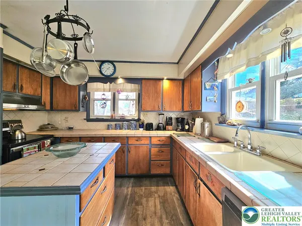 a kitchen with stainless steel appliances granite countertop a sink a stove top oven a counter space and cabinets