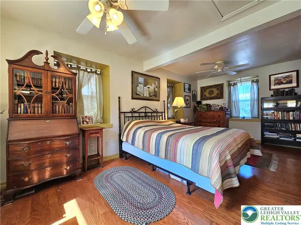 a bedroom with a bed a dresser and book shelf