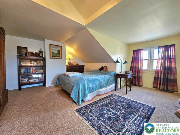 a bedroom with a bed a dresser and book shelf