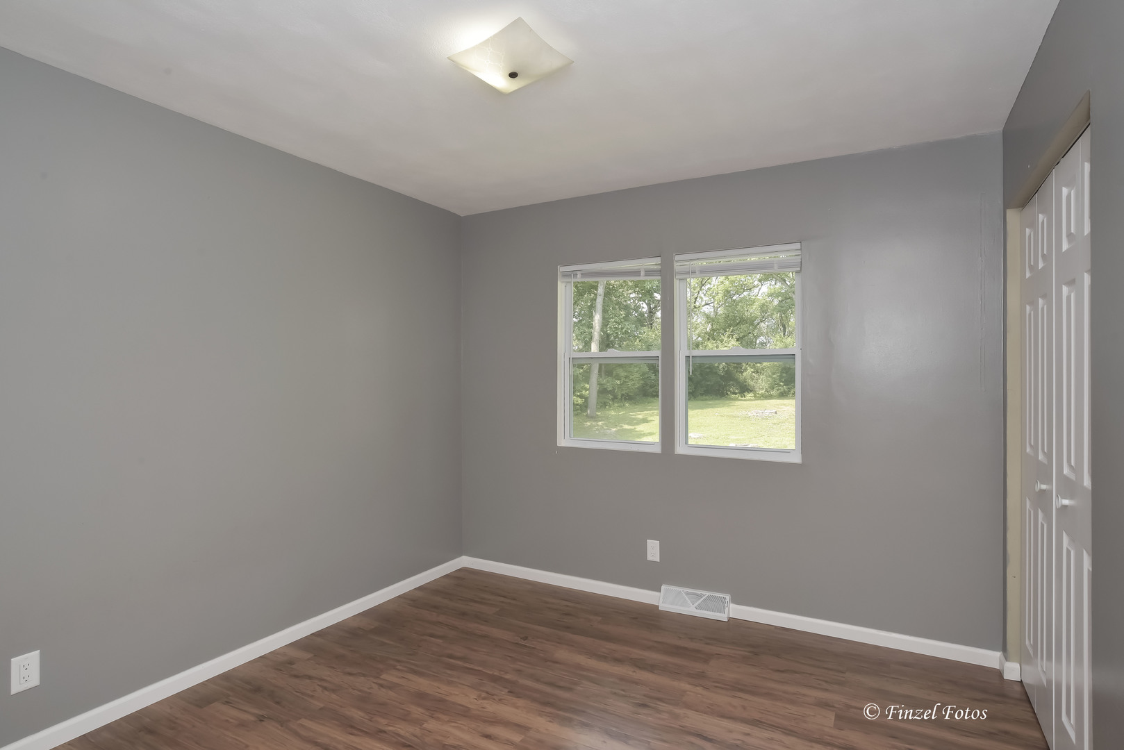 1009 Hickory Road Woodstock, IL 60098 - Photo 12 of 18 an empty room with wooden floor and windows