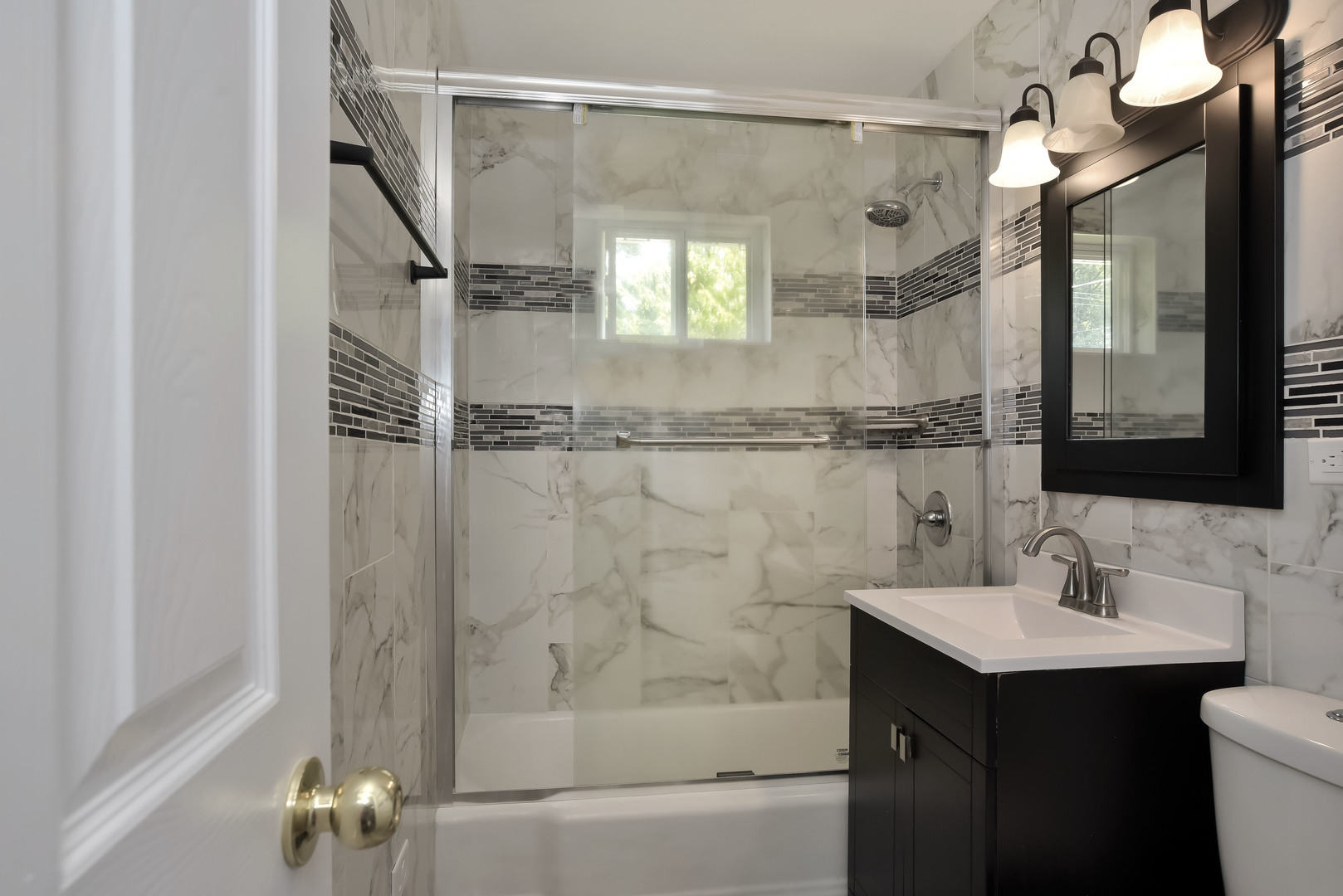 1009 Hickory Road Woodstock, IL 60098 - Photo 9 of 18 a bathroom with a sink mirror and a shower