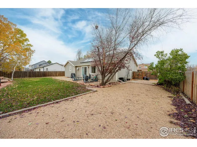 a view of a house with backyard and sitting area