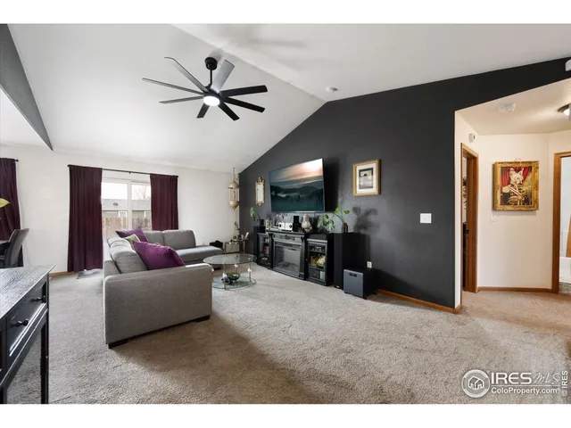 a living room with furniture and a ceiling fan
