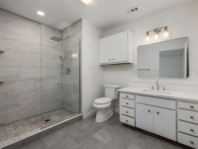 a bathroom with a double vanity sink toilet and shower