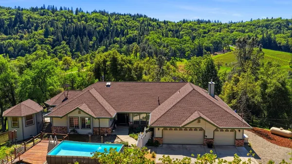 a aerial view of a house with table and chairs under an umbrella