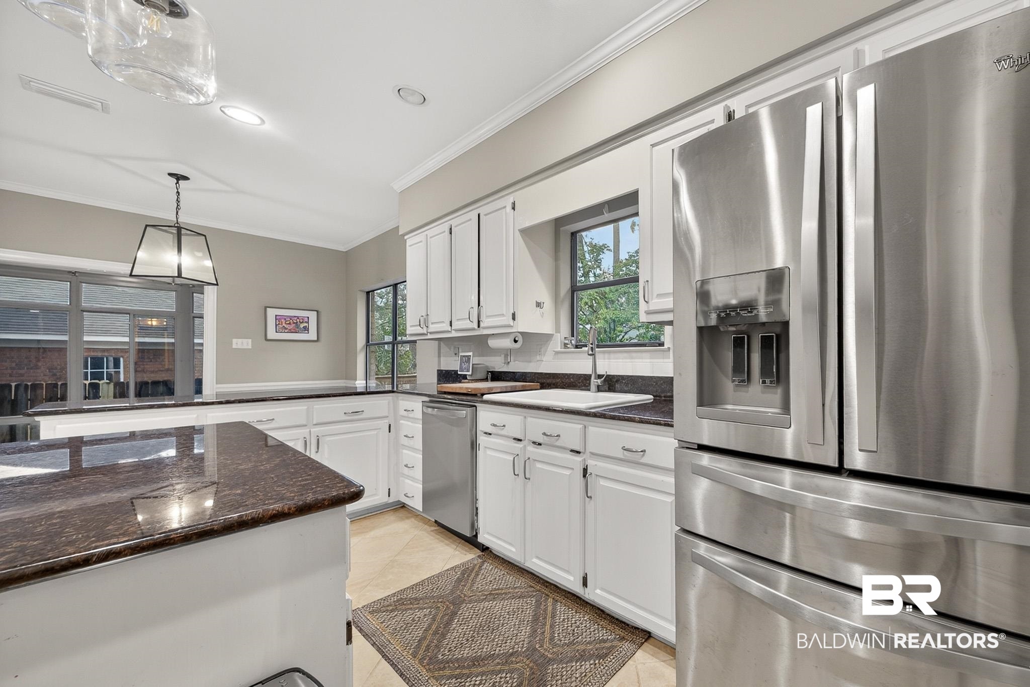 1250 Savannah Drive Mobile, AL 36609 - Photo 17 of 35 Kitchen with stainless steel appliances, ornamental molding, dark stone countertops, white cabinetry, and pendant lighting