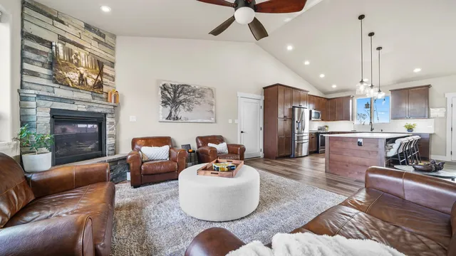 a living room with stainless steel appliances furniture a fireplace and a view of kitchen