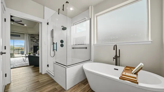 a bathroom with a white bath tub a mirror and a shower
