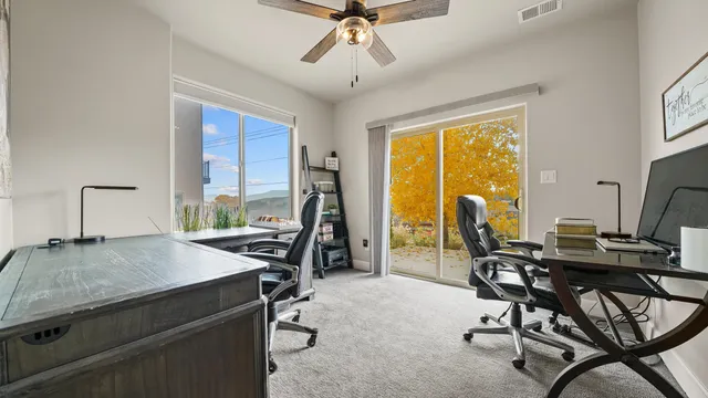 a view of a workspace with furniture and a window
