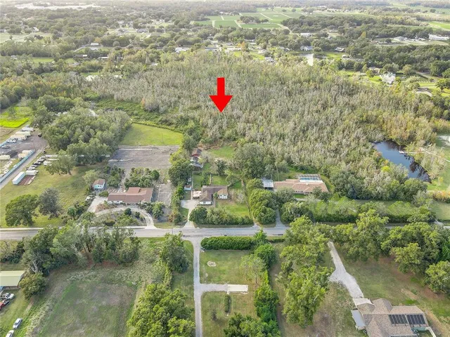 an aerial view of residential houses with outdoor space and trees