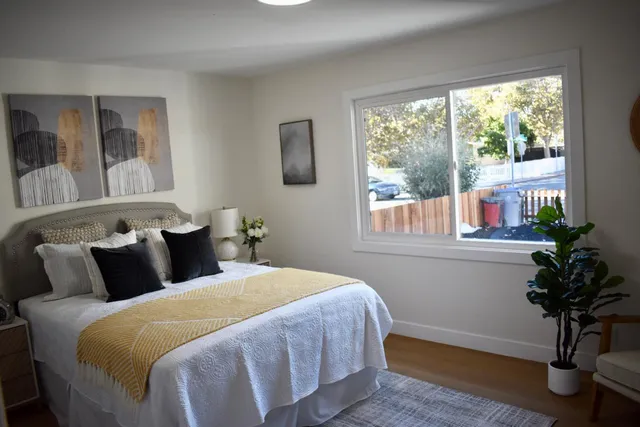 a bedroom with a large bed and a potted plant