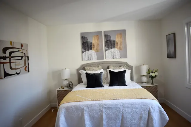 a bedroom with a bed and painting on the wall