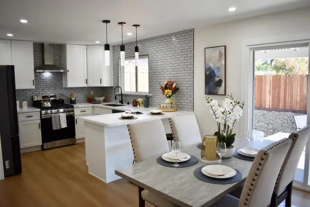a kitchen with sink refrigerator dining table and chairs