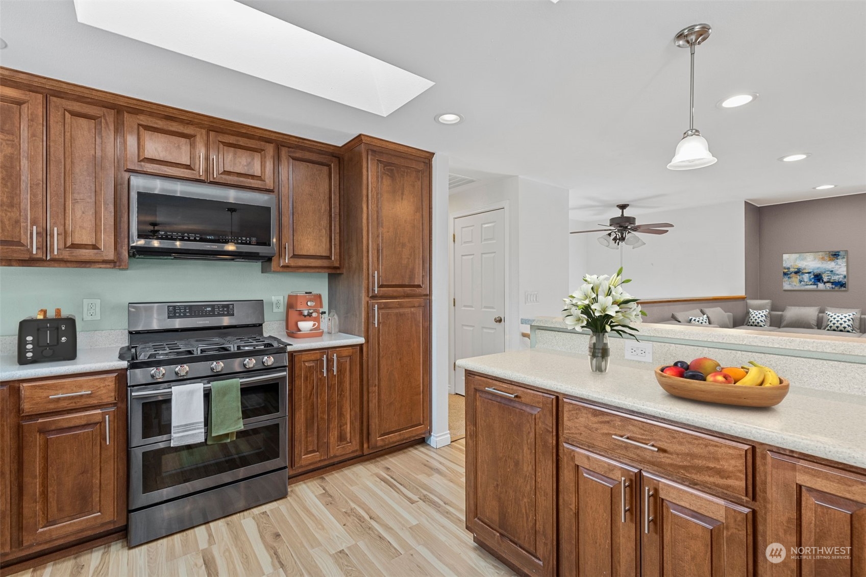 10823 23rd Drive Southeast Everett, WA 98208 - Photo 8 of 39 a kitchen with granite countertop wooden cabinets stainless steel appliances and a wooden floor