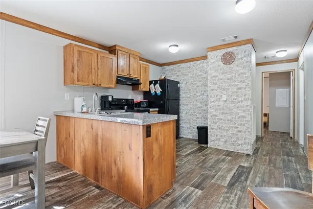 a kitchen with stainless steel appliances granite countertop a refrigerator sink and stove