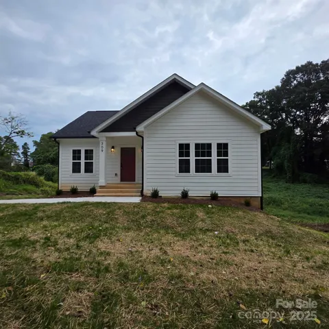 a backyard of a house with potted plants and wooden fence