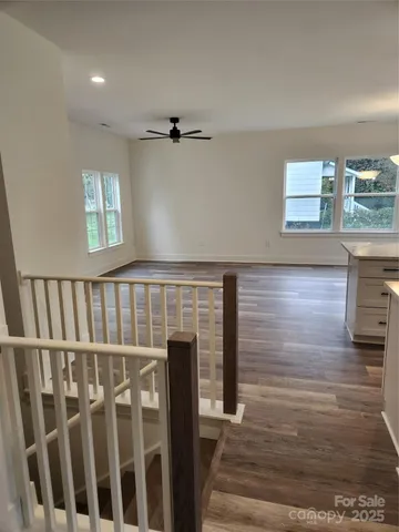 a view of a hallway with wooden floor and staircase