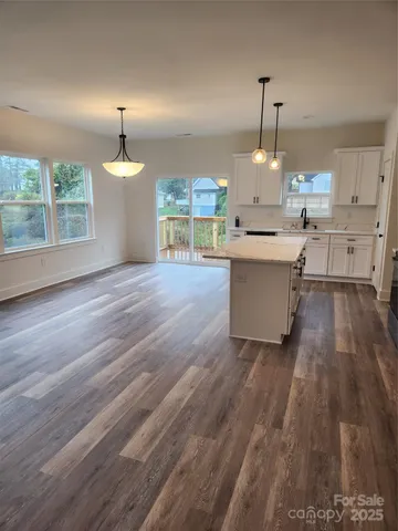a view of a kitchen with furniture and wooden floor