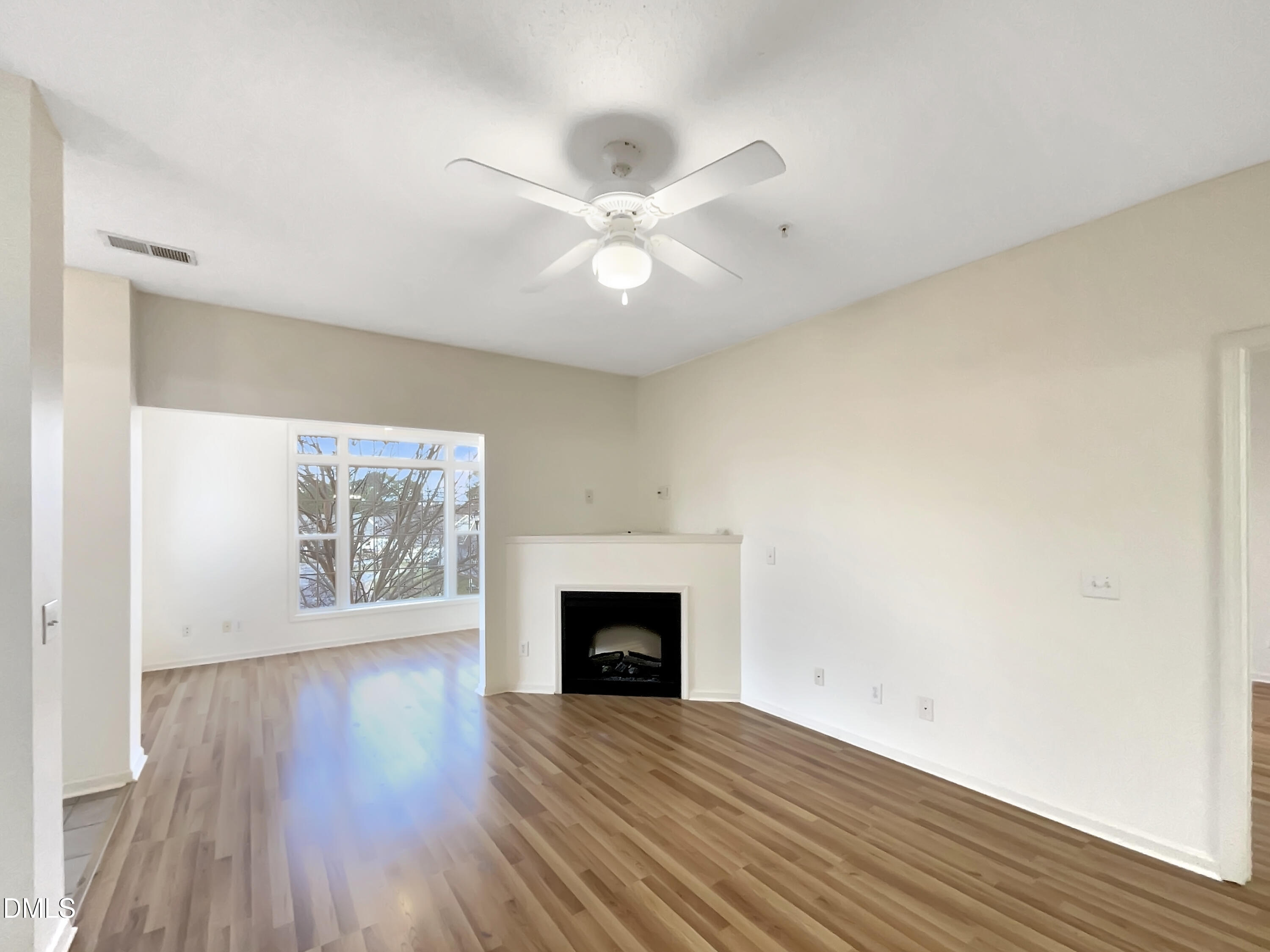 2501 Huntscroft Lane, Unit 203 Raleigh, NC 27617 - Photo 3 of 16 an empty room with wooden floor a ceiling fan and windows