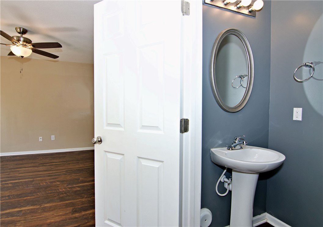 305 North Chestnut Street Seneca, SC 29678 - Photo 21 of 44 A classic pedestal sink in the powder room, complemented by sleek wood flooring in the adjacent living space.