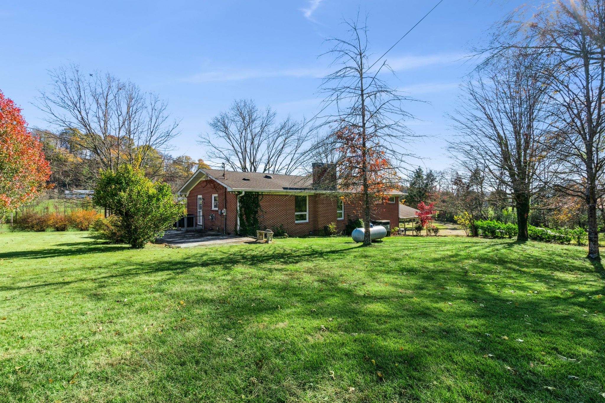 2621 Knob Creek Road Columbia, TN 38401 - Photo 3 of 9 a yellow house sitting in middle of the grass and covered with trees