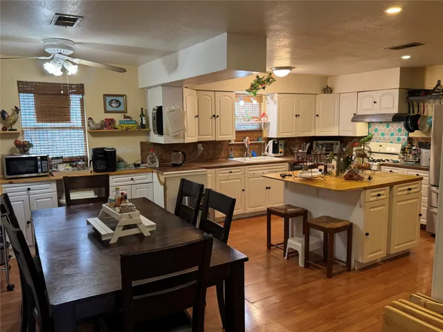 a kitchen with a table chairs stove and cabinets