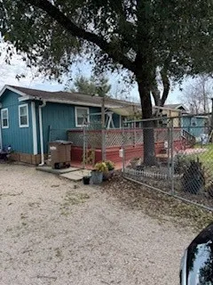 a view of house with backyard and chairs