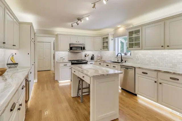a kitchen with granite countertop a sink stainless steel appliances and cabinets