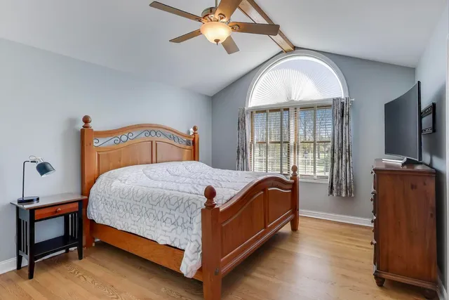 a bedroom with a bed and wooden floor