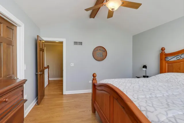 a bedroom with a bed and a flat tv screen on dresser