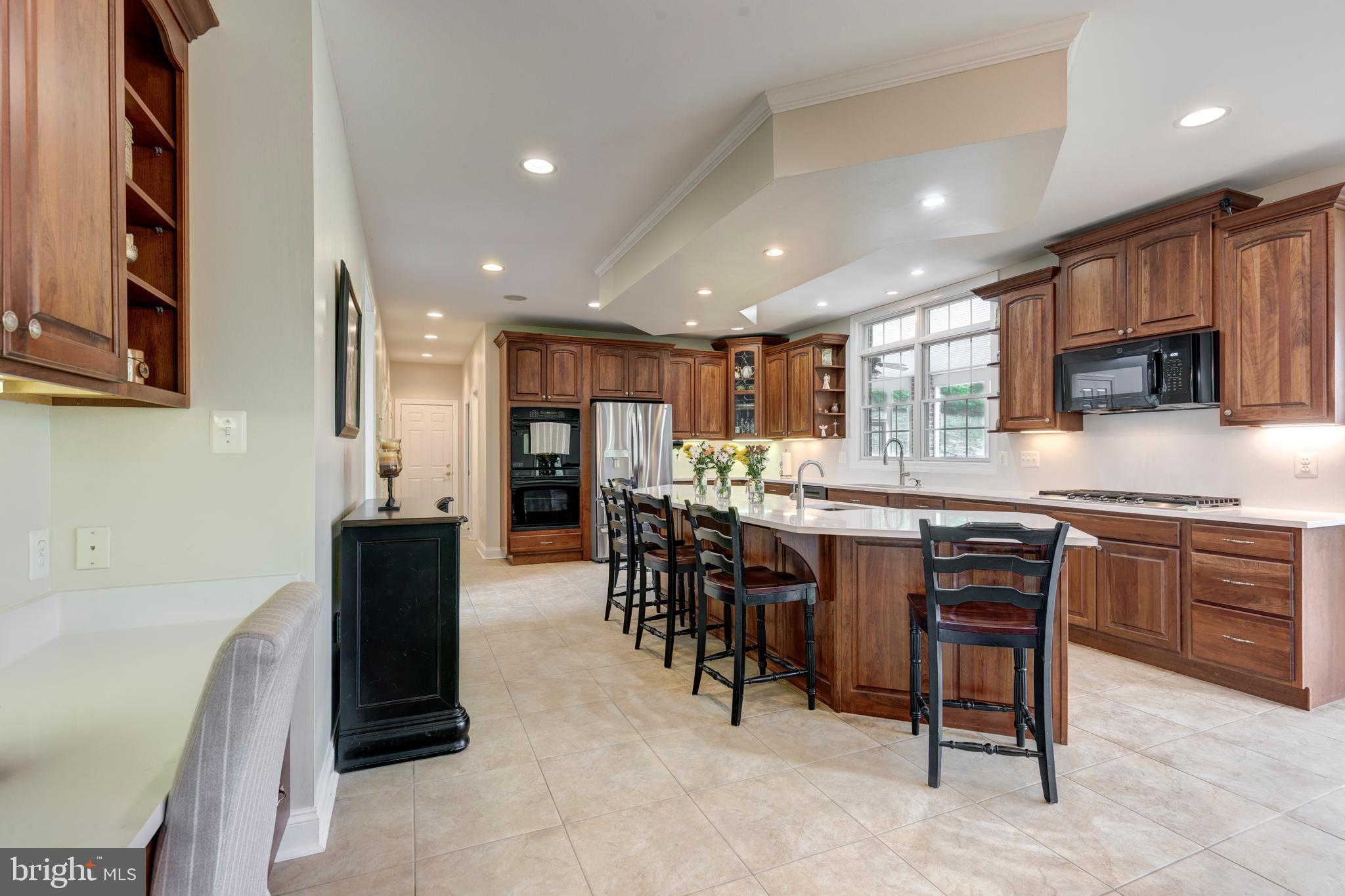 2995 Sams Creek Road New Windsor, MD 21776 - Photo 52 of 126 a kitchen with stainless steel appliances kitchen island granite countertop a table chairs sink and cabinets